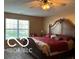 Cozy bedroom with a large bed, a ceiling fan, and a bright window at 804 Seabreeze Dr, Avon, IN 46123