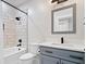 This bathroom features a shower with a white tiled wall, gray vanity and modern fixtures at 807 E Minnesota St, Indianapolis, IN 46203