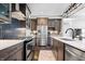 Modern kitchen boasts stainless steel appliances, dark cabinetry, chic backsplash, and gas range at 807 E Minnesota St, Indianapolis, IN 46203