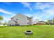 View of the backyard featuring a stone firepit and green lawn at 8531 Aberdeenshire Ct, Indianapolis, IN 46259