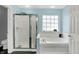 Bathroom featuring a glass-enclosed shower, soaking tub, and natural light from the window at 8531 Aberdeenshire Ct, Indianapolis, IN 46259