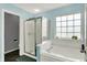 Bathroom featuring a glass-enclosed shower, soaking tub, and natural light from the window at 8531 Aberdeenshire Ct, Indianapolis, IN 46259