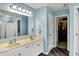 Bathroom featuring a double sink vanity, ample lighting, large mirror and walk-in closet at 8531 Aberdeenshire Ct, Indianapolis, IN 46259