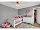 Bedroom with a white bed, pink flowers on the wall, dresser, and colorful rug at 8531 Aberdeenshire Ct, Indianapolis, IN 46259