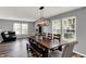 Bright dining room featuring a wooden table, modern chandelier, and lots of natural light from large windows at 8531 Aberdeenshire Ct, Indianapolis, IN 46259