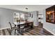 Stylish dining room featuring hardwood floors, a modern chandelier, and glimpses of the kitchen at 8531 Aberdeenshire Ct, Indianapolis, IN 46259
