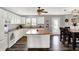 Open kitchen featuring white cabinets, an island, hardwood floors, and views of the adjacent dining area at 8531 Aberdeenshire Ct, Indianapolis, IN 46259