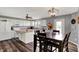 Bright kitchen featuring white cabinets, stainless steel appliances, island, and dining table in a neutral color palette at 8531 Aberdeenshire Ct, Indianapolis, IN 46259