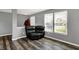 Inviting living room featuring a leather recliner chair, neutral walls, and hardwood floors and large windows at 8531 Aberdeenshire Ct, Indianapolis, IN 46259