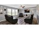 Cozy living room with hardwood floors, large windows, ceiling fan, and comfortable leather seating at 8531 Aberdeenshire Ct, Indianapolis, IN 46259