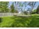 Large fenced backyard featuring a concrete basketball court and mature trees at 8560 N College Ave, Indianapolis, IN 46240