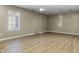 An empty basement room featuring laminate wood flooring and a single window at 8560 N College Ave, Indianapolis, IN 46240