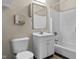Modest bathroom with a shower-tub combo, white vanity, toilet, and large mirror at 8560 N College Ave, Indianapolis, IN 46240