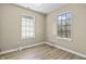 This bedroom features light tan walls, wood-look floors, and two windows to let in natural light at 8560 N College Ave, Indianapolis, IN 46240