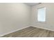 This empty bedroom features wood-look floors, light tan walls, and a window with blinds at 8560 N College Ave, Indianapolis, IN 46240