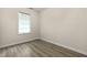A simple bedroom features wood-look floors, light walls, and a window with closed blinds at 8560 N College Ave, Indianapolis, IN 46240