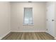 Empty bedroom featuring wood-look floors, light walls, and a window with blinds at 8560 N College Ave, Indianapolis, IN 46240