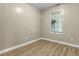 An empty bedroom with clean, neutral walls and light wood-look laminate flooring at 8560 N College Ave, Indianapolis, IN 46240
