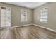 A bedroom featuring two windows and laminate wood flooring at 8560 N College Ave, Indianapolis, IN 46240