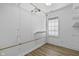 A bright closet featuring wood-look floors, white walls, window and closet rod with shelving above at 8560 N College Ave, Indianapolis, IN 46240