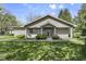 Tan home featuring a covered porch with bushes out front and an overgrown lawn at 8560 N College Ave, Indianapolis, IN 46240