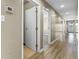 A long hallway featuring several doorways and laminate wood flooring at 8560 N College Ave, Indianapolis, IN 46240