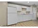 Kitchen features white cabinets, white refrigerator, wood floors, and beige walls at 8560 N College Ave, Indianapolis, IN 46240