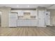 Kitchen features white cabinets, white refrigerator, wood floors, and beige walls at 8560 N College Ave, Indianapolis, IN 46240