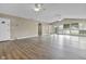 Open concept living room features wood floors, multiple ceiling fans, and beige walls at 8560 N College Ave, Indianapolis, IN 46240