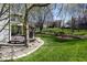 Spacious backyard featuring lush green grass, mature trees, and a deck with outdoor seating at 9789 Logan Ln, Fishers, IN 46037