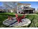 Backyard featuring a stone fire pit area surrounded by Adirondack chairs on a well-maintained lawn at 9789 Logan Ln, Fishers, IN 46037