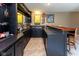 Basement bar featuring dark cabinetry, a tile backsplash, and seating for entertaining guests at 9789 Logan Ln, Fishers, IN 46037