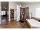 Luxurious bathroom featuring a glass enclosed shower, soaking tub, modern light fixture, and spacious walk-in closet at 9789 Logan Ln, Fishers, IN 46037