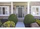 Inviting front entrance with a gray door, brick facade, sidelights and manicured shrubbery at 9789 Logan Ln, Fishers, IN 46037