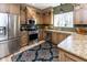 Well-lit kitchen featuring stainless steel appliances, granite countertops, and custom wood cabinetry at 9789 Logan Ln, Fishers, IN 46037