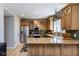 Bright, open kitchen with stainless steel appliances, wooden cabinets, granite countertops, and an island at 9789 Logan Ln, Fishers, IN 46037