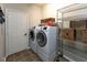 Bright laundry room featuring a modern washer and dryer, shelving, and tile flooring at 9789 Logan Ln, Fishers, IN 46037