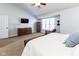 Inviting main bedroom featuring a large window, ceiling fan, dresser, television, and a comfortable chair at 9789 Logan Ln, Fishers, IN 46037