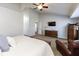 Well-lit main bedroom featuring a ceiling fan, flat screen tv, dresser, and comfortable sitting area at 9789 Logan Ln, Fishers, IN 46037