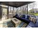 Comfortable screened-in porch with a large seating area and cozy gas fireplace at 9789 Logan Ln, Fishers, IN 46037
