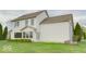 Backyard view of a two-story home with a well-kept lawn and manicured landscaping at 9844 Plantana Blvd, Fishers, IN 46038