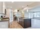 Updated kitchen features an island with a sink, stainless steel appliances, and a view into the living area at 9844 Plantana Blvd, Fishers, IN 46038