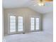 Bright living room features vaulted ceilings, a ceiling fan, and doors to a patio or balcony at 9844 Plantana Blvd, Fishers, IN 46038