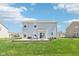 Backyard of a two-story home with a concrete patio and outdoor furniture perfect for entertaining at 9916 Gallop Ln, Fishers, IN 46040