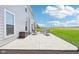 Concrete patio with outdoor seating and a storage container surrounded by green grass and clear blue skies at 9916 Gallop Ln, Fishers, IN 46040