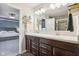Bright bathroom boasts double vanity, stylish fixtures, and a walk-in shower with modern gray tile at 9916 Gallop Ln, Fishers, IN 46040