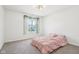 Cozy bedroom with a bed, a window adorned with vines, and a modern ceiling fan at 9916 Gallop Ln, Fishers, IN 46040