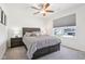 Cozy bedroom with a comfortable bed, a ceiling fan, and a window that provides a view of the outside at 9916 Gallop Ln, Fishers, IN 46040