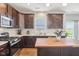 Well-equipped kitchen with dark cabinets, countertops, and stainless steel appliances at 9916 Gallop Ln, Fishers, IN 46040