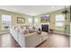 Cozy living room featuring a fireplace, large sectional sofa, and multiple windows at 9916 Gallop Ln, Fishers, IN 46040